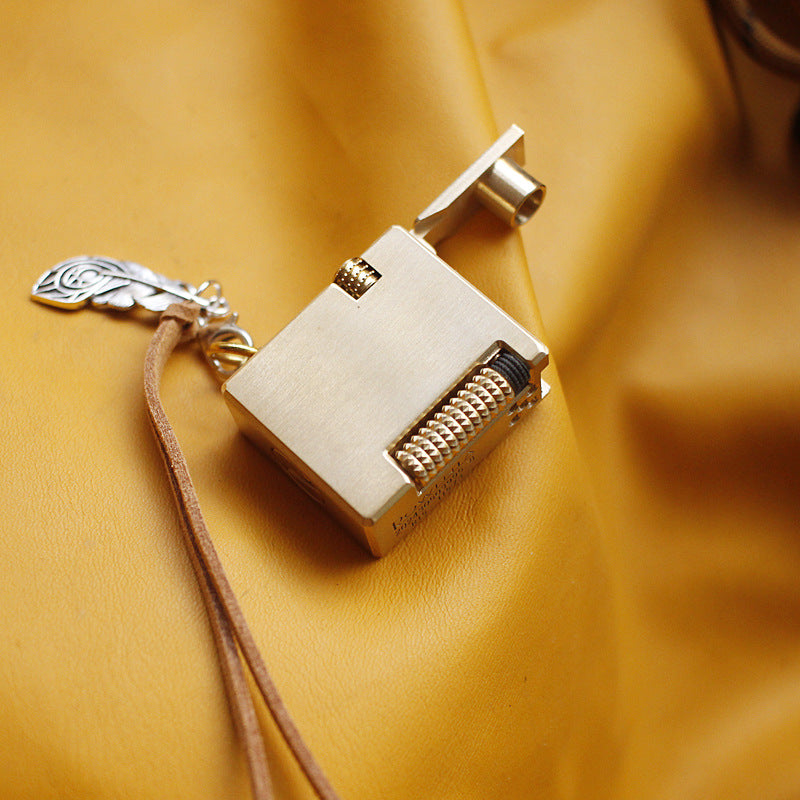 Vintage brass oil lighter keychain hanging, refillable petrol lighter close-up