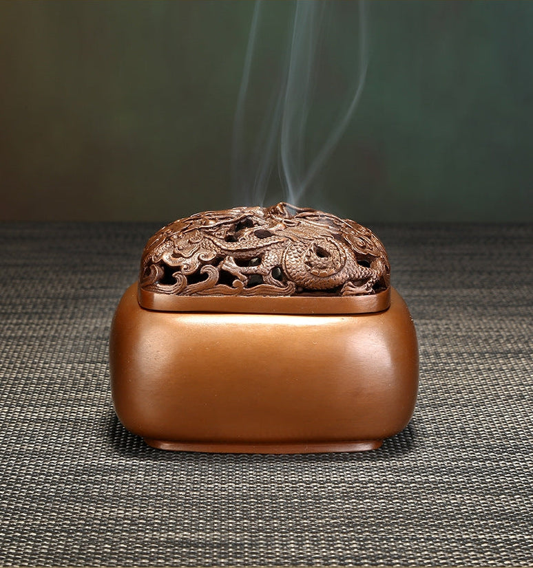 Decorative incense burner with intricate design on a textured surface