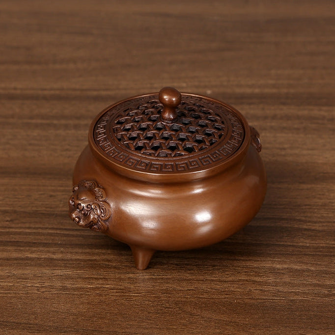 Bronze incense burner with lion-head handles displayed in a private study
