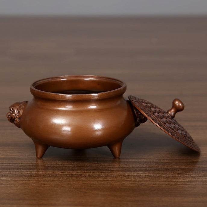 Bronze incense burner with lion-head handles displayed in a private study
