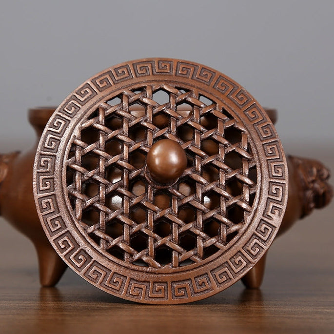Bronze incense burner with lion-head handles displayed in a private study