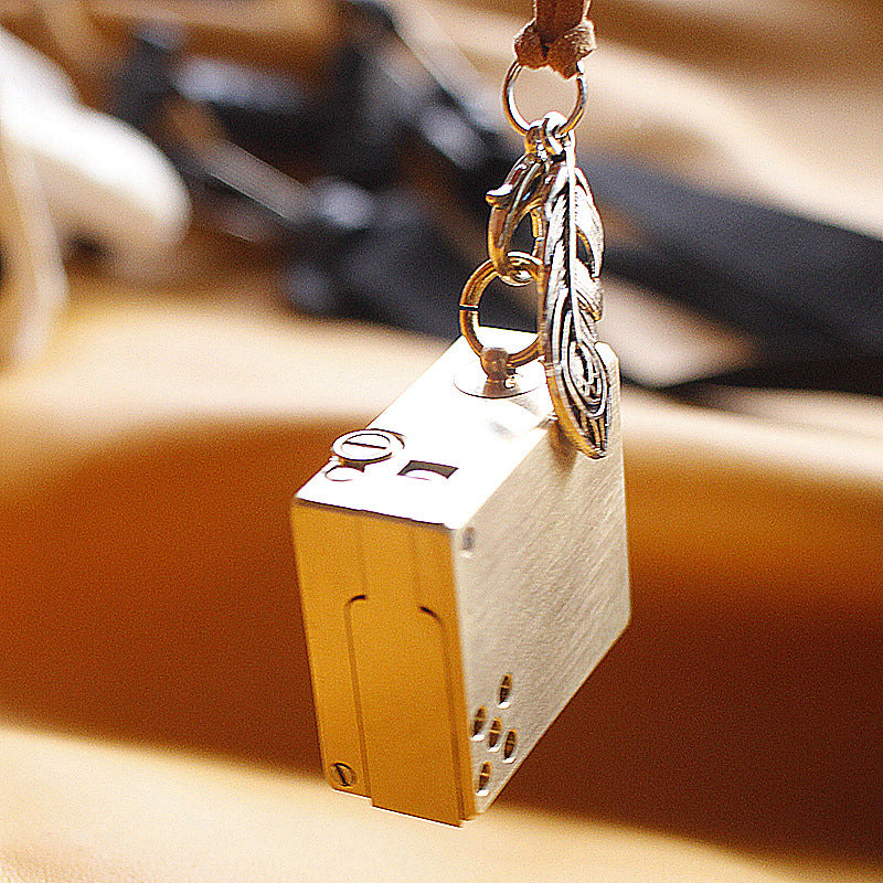 Vintage brass oil lighter keychain hanging, refillable petrol lighter close-up