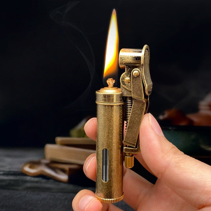 Handheld vintage brass oil lighter ignited with flame, refillable petrol lighter close-up

