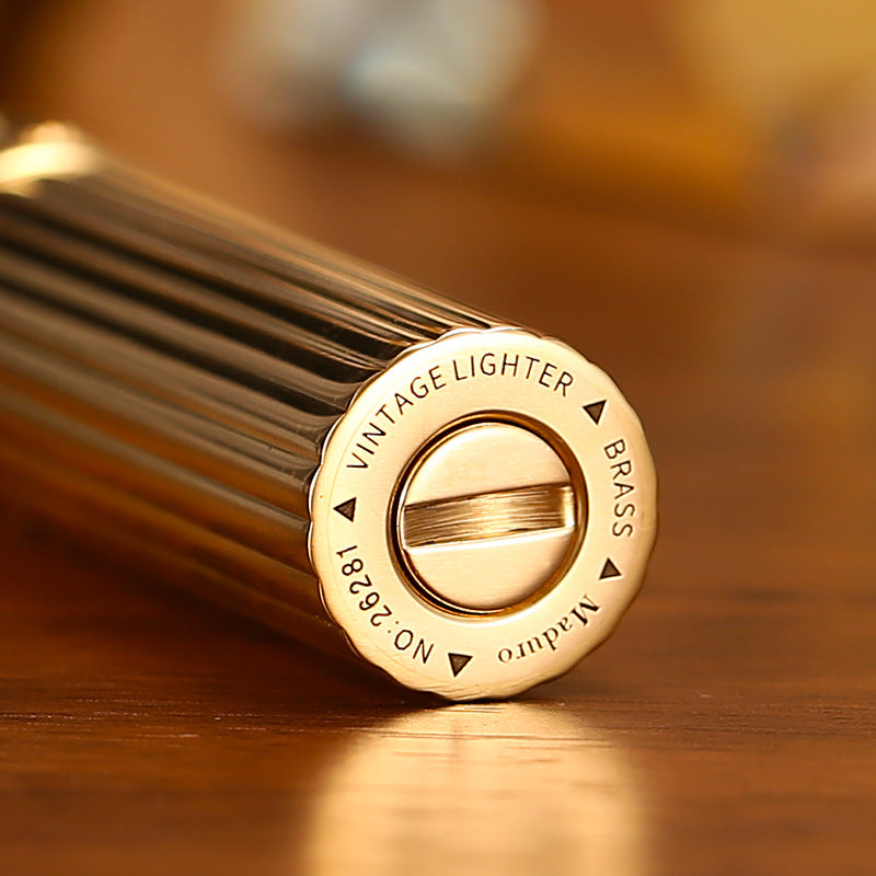 Vintage brass oil lighter with ribbed design standing upright, refillable petrol lighter
