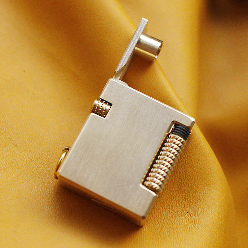 Vintage brass oil lighter keychain hanging, refillable petrol lighter close-up