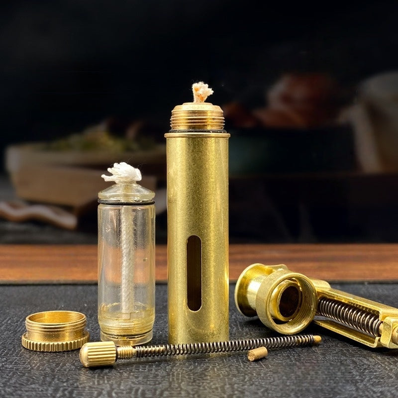 Handheld vintage brass oil lighter ignited with flame, refillable petrol lighter close-up
