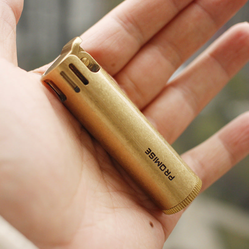 Vintage brass oil lighter with antique finish resting on leather, refillable petrol lighter