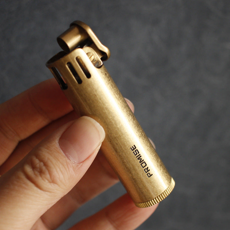 Vintage brass oil lighter with antique finish resting on leather, refillable petrol lighter