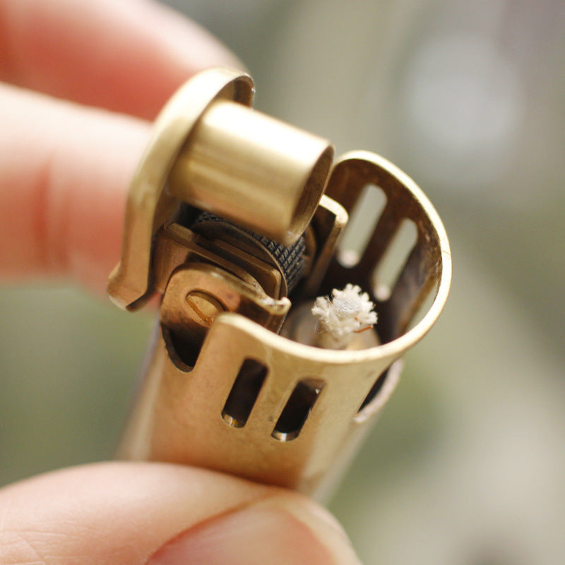 Vintage brass oil lighter with antique finish resting on leather, refillable petrol lighter