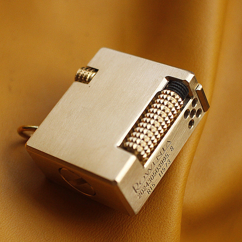 Vintage brass oil lighter keychain hanging, refillable petrol lighter close-up