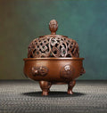 Decorative wooden incense burner with intricate carvings on a textured surface.